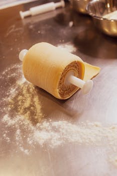 Close-up of fresh pasta dough rolled in a kitchen setting, showcasing Italian culinary tradition.