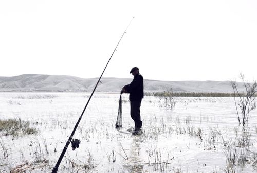 Free Silhouette of a fisherman standing in a serene lake in Konya, Türkiye. Stock Photo