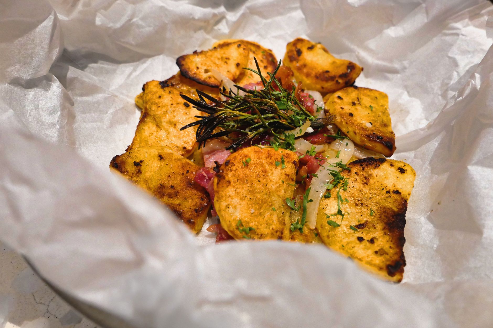 Plated baked potato foil packets with fresh herbs and side salad