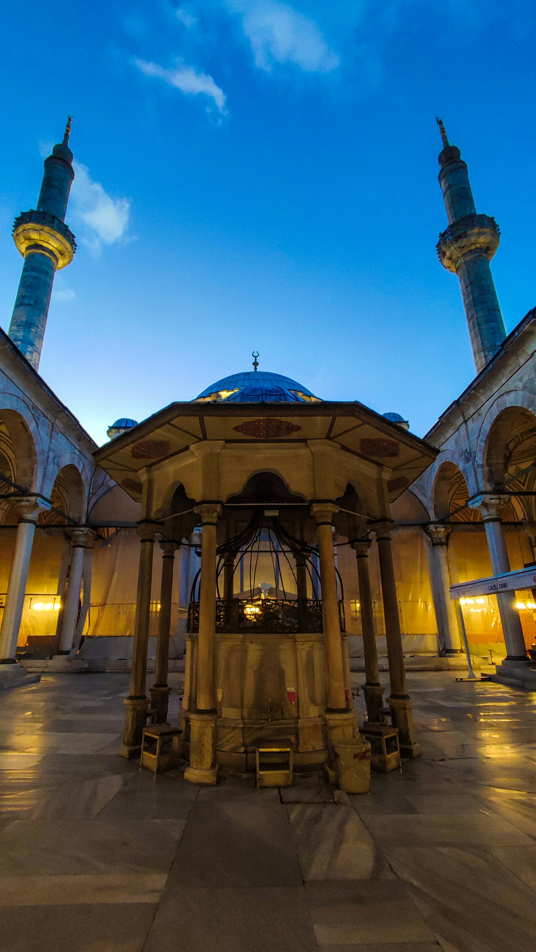 Twilight view of Laleli Mosque courtyard in Istanbul, showcasing its Ottoman architecture.