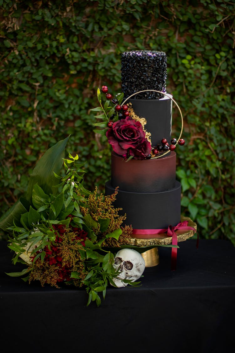 An Artistic Set-up Of A Halloween Decor With Leaves Flowers Skull And A Tier Of Painted Containers