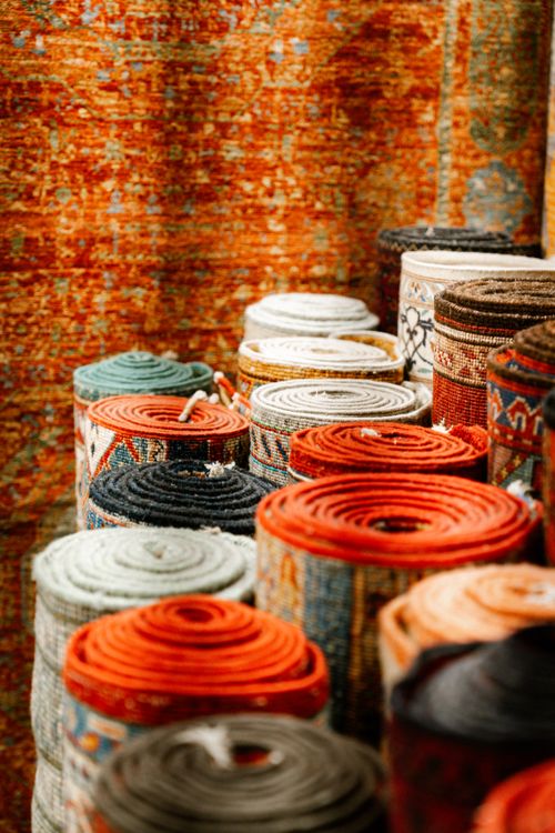 Persian Rugs Roled Up Colorful Rolled Persian Rugs on Display · Free Stock Photo