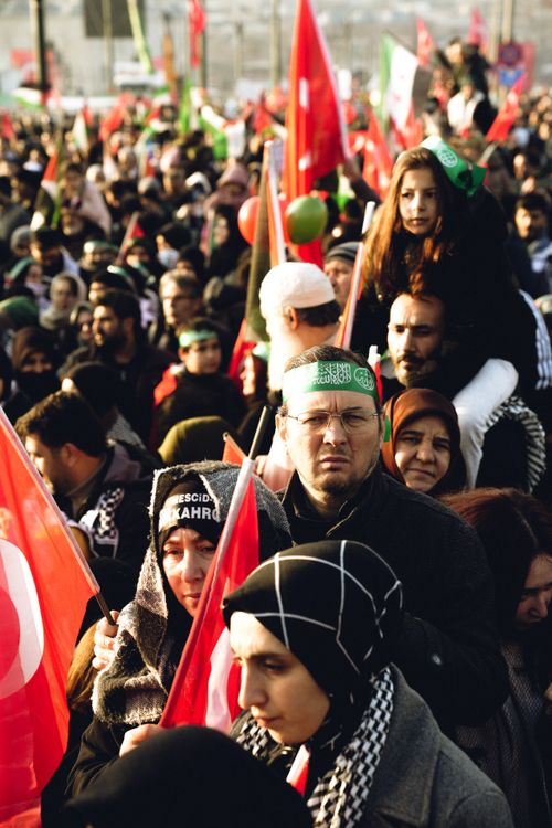Free Crowd gathered at a peaceful protest with flags and banners in a city square. Stock Photo