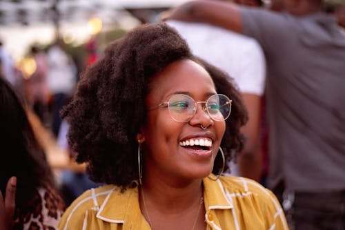 Young Woman in Eyeglasses and Yellow Shirt Smiling