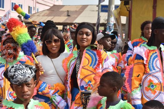 A lively street festival with people in colorful traditional costumes celebrating joyously.