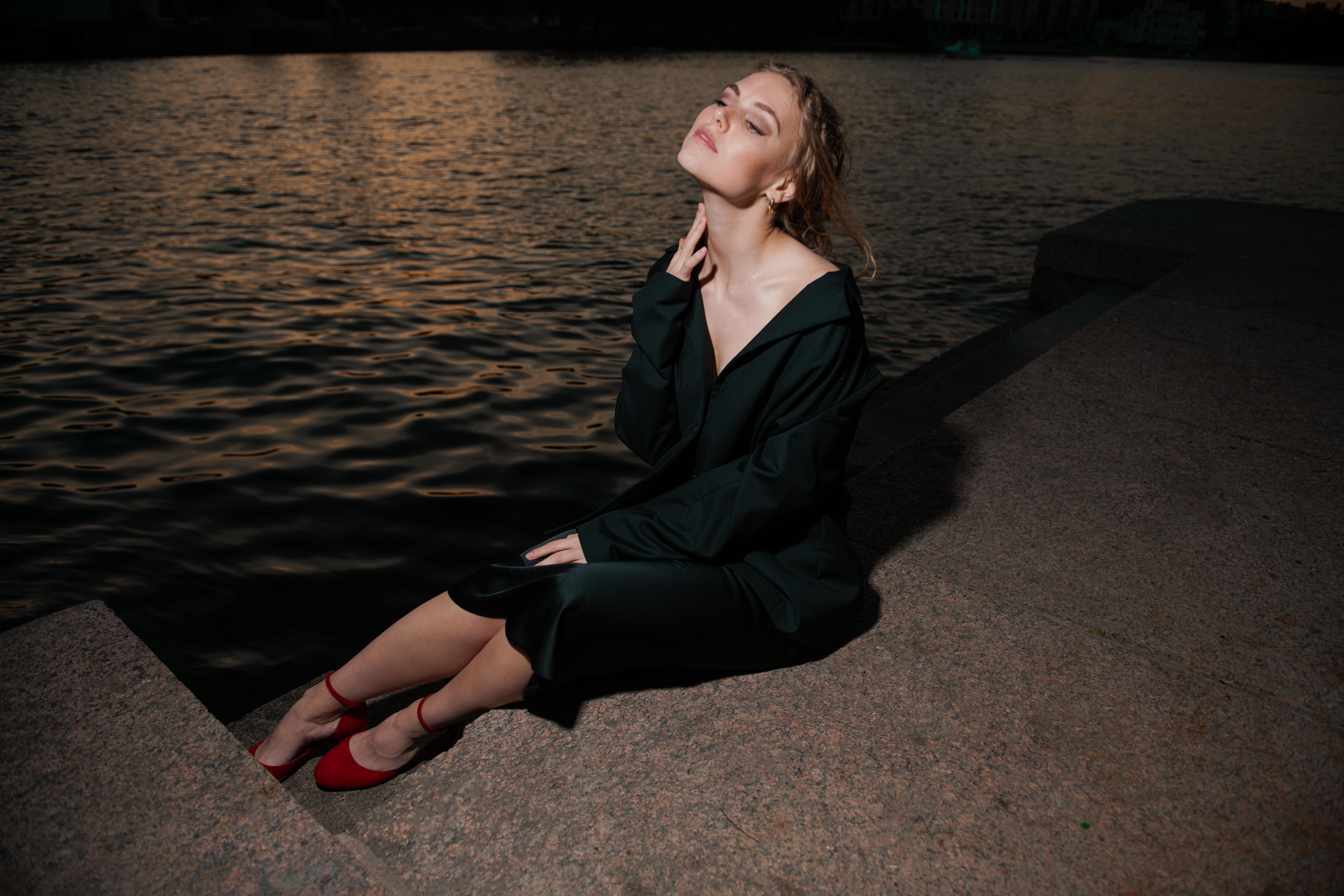 Contemplative Woman Sitting Lakeside at Twilight · Free Stock Photo
