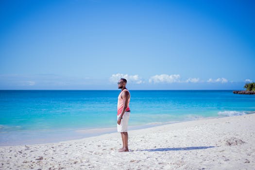 在坦桑尼亚宁静的沙滩上，一名男子凝视着清澈的蓝色海洋