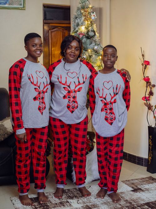 Free Family wearing matching pajamas celebrating Christmas at home. Stock Photo