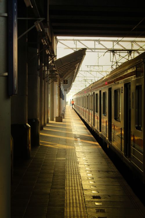 Free A serene view of a train platform in Jakarta during golden hour lighting. Stock Photo