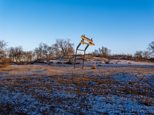 Free Winter landscape with an old sign and bare trees under a clear sky. Stock Photo