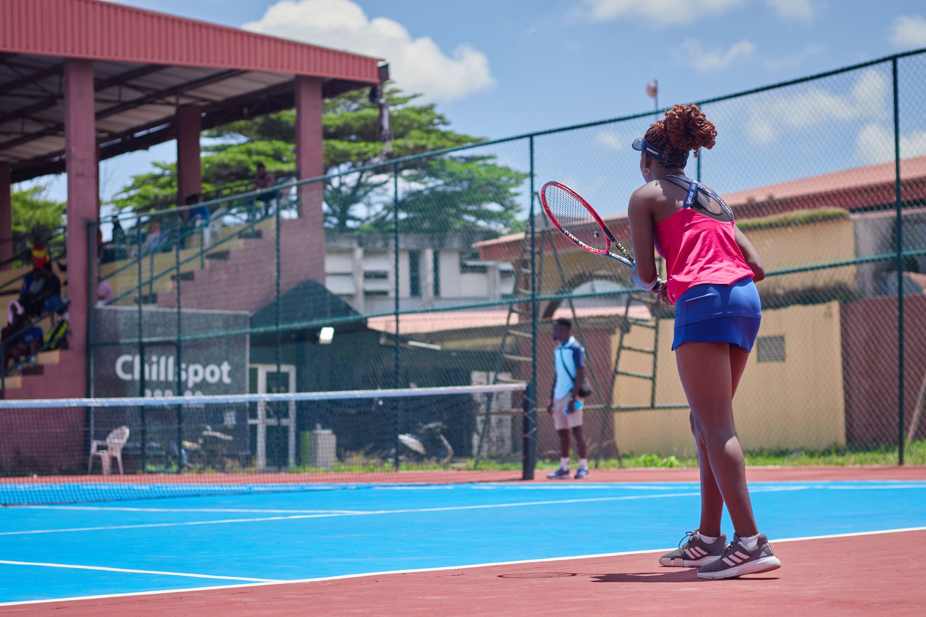 A woman playing tennis on a sunny day, showcasing her skills on an outdoor court.
