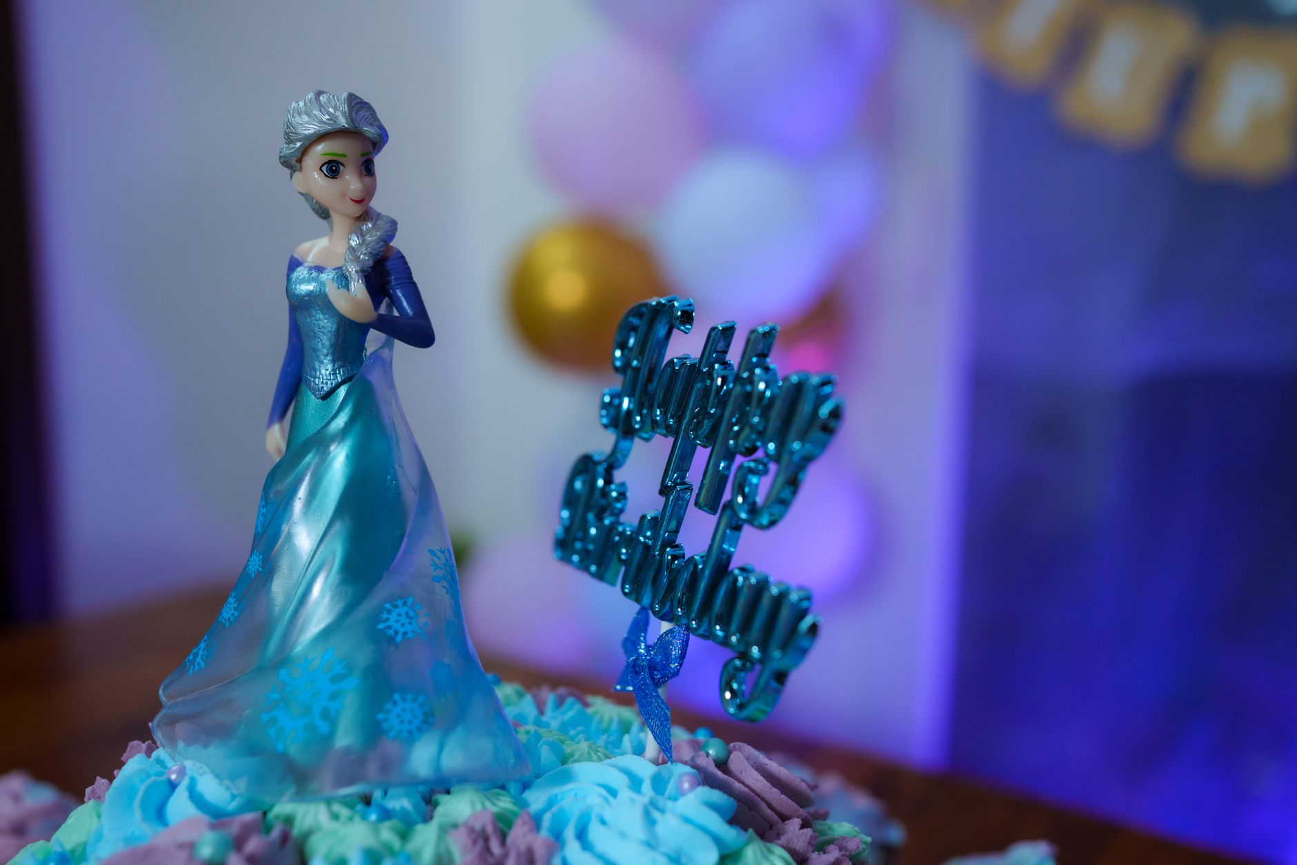 Beautiful Frozen themed birthday cake featuring a doll topper and vibrant decorations, perfect for children's parties.