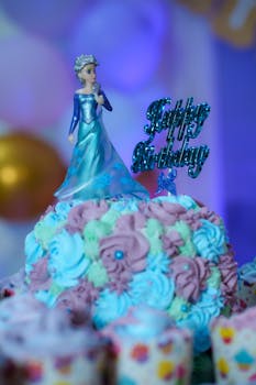 A Frozen-themed birthday cake with an intricate doll topper in vibrant colors, perfect for a child's celebration.