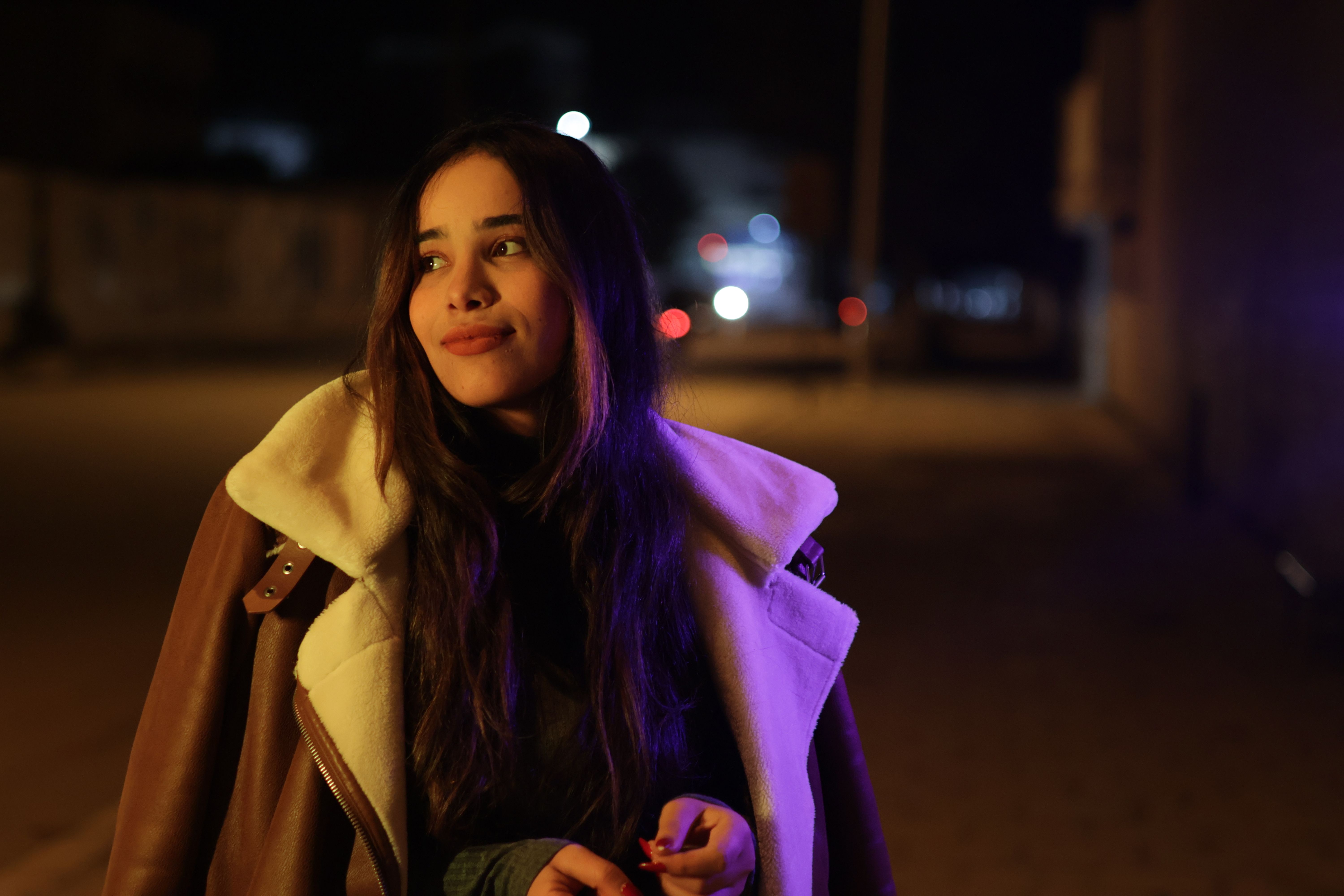 Young Woman Smiling at Night on City Street · Free Stock Photo