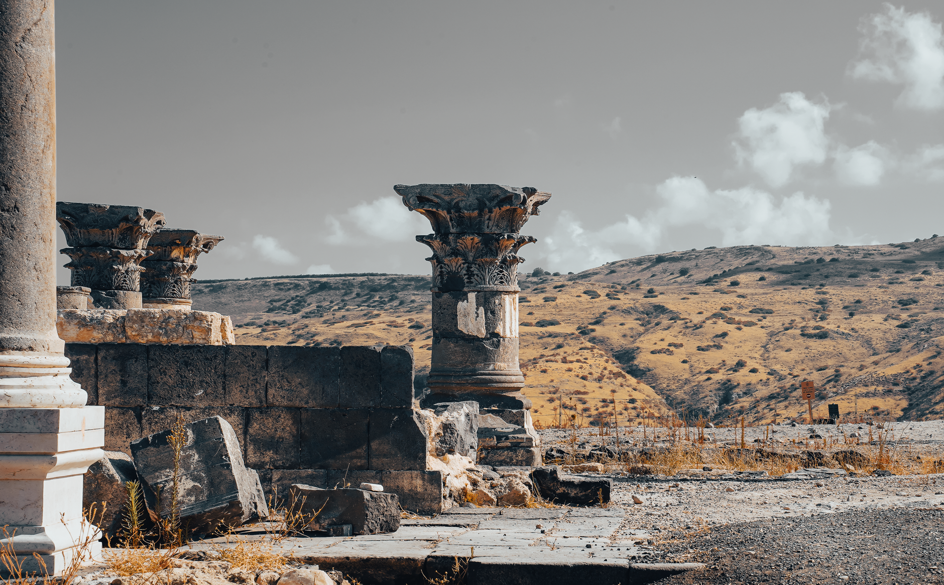Explore the ancient stone pillars of historical ruins set against a rugged landscape.