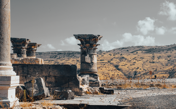 Explore the ancient stone pillars of historical ruins set against a rugged landscape.
