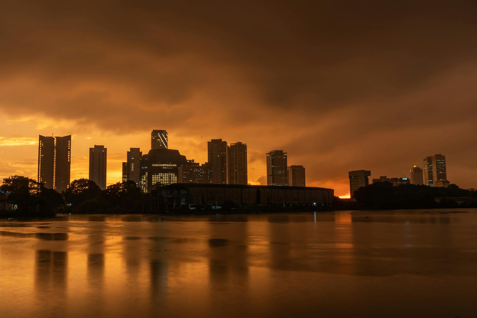 Stunning view of Colombo city skyline reflecting on the water at sunset.