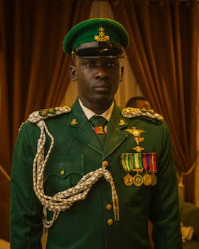 Portrait of a Nigerian military officer in formal green uniform with medals.