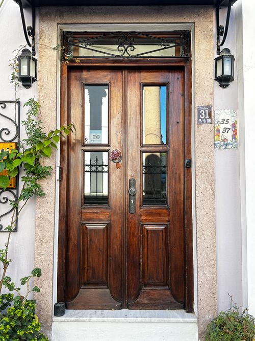 Free A beautifully crafted wooden entrance door with decorative features in Ayvalık, Türkiye. Stock Photo