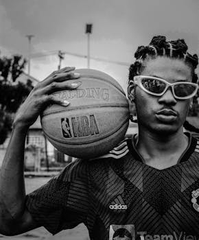 Black and white portrait of a young basketball player holding an NBA ball.