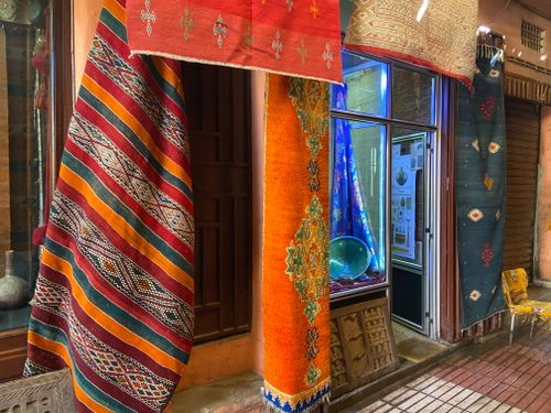 Free Vibrant handmade rugs hanging in a Taroudant market showcasing Moroccan craftsmanship. Stock Photo