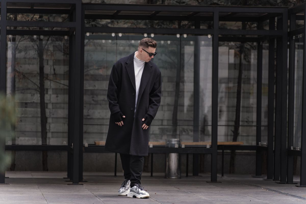 Chàng trai mặc streetwear rộng thoải mái với áo graphic tee và quần jogger đi ngoài phố