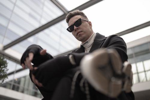 Free Man in black outfit and sunglasses posing in a contemporary urban environment. Stock Photo