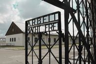 Entrance gate of Dachau concentration camp featuring the inscription 'Arbeit Macht Frei'.