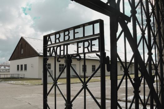 Entrance gate of Dachau concentration camp featuring the inscription 'Arbeit Macht Frei'.
