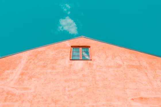 Coral building gable against a teal sky, photo by Vlado Paunovic on Pexels
