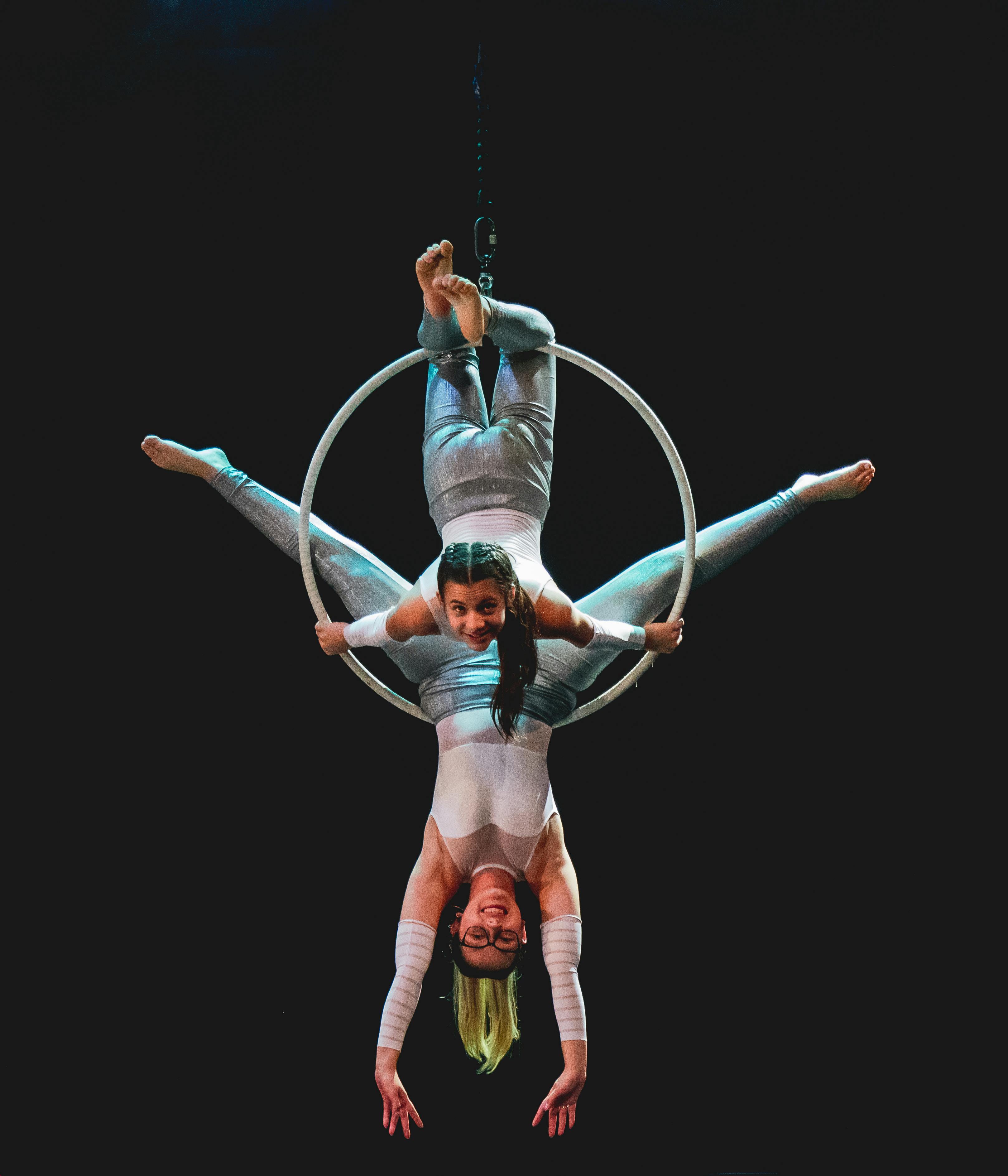 common:alt.prefix Dos artistas ejecutando una impresionante rutina de danza aérea con aros en el escenario. common:alt.postfix