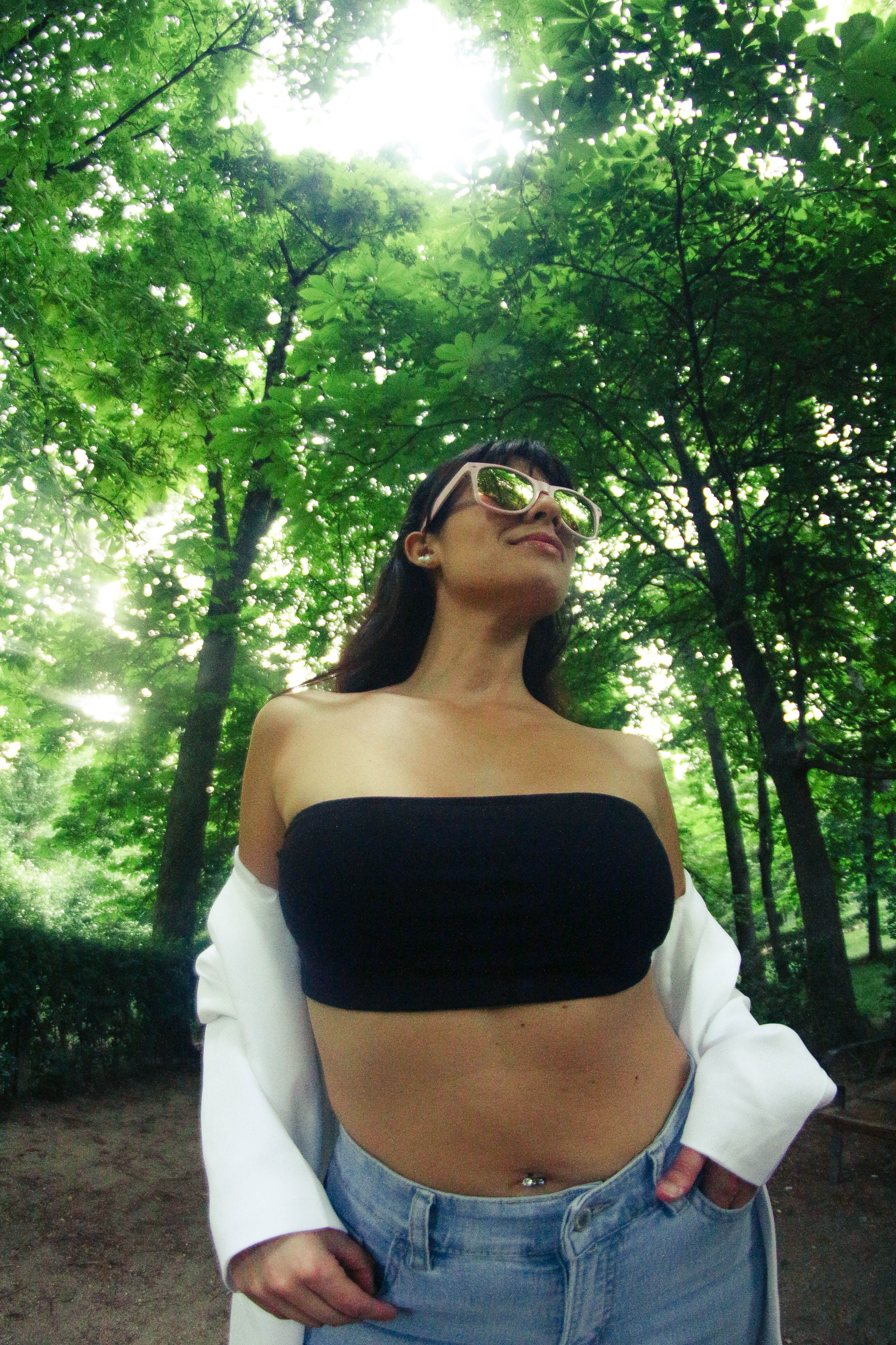 Stylish woman in sunglasses enjoying nature in Madrid forest on a summer day.
