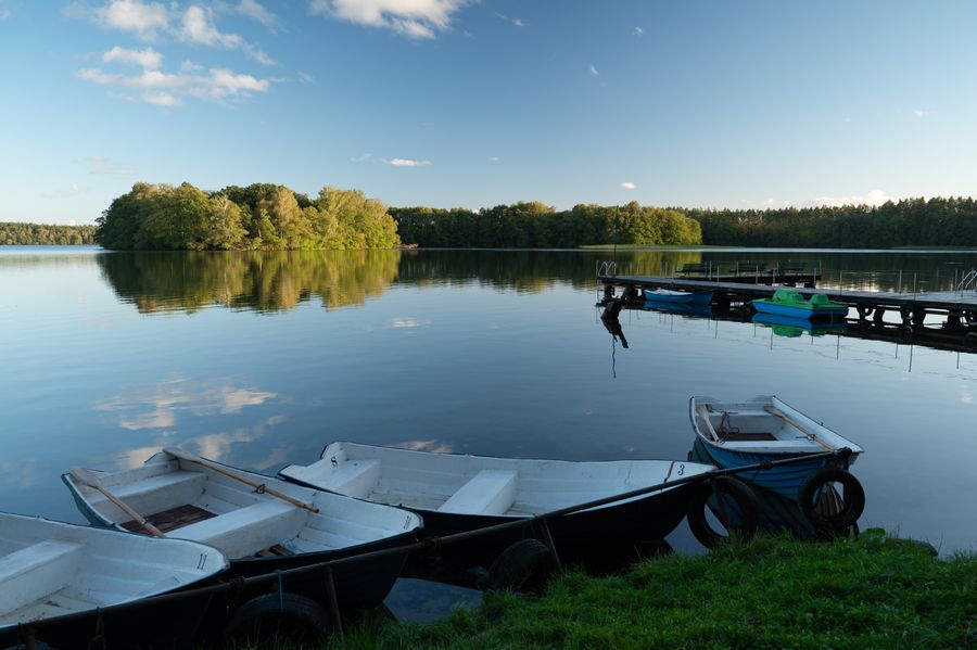 Boats moored at a wooden dock in the evening light