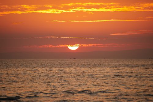 Free A breathtaking orange sunset over the calm sea, showcasing vibrant colors and tranquility. Stock Photo