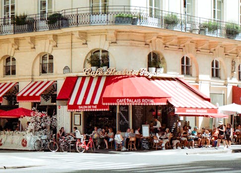 A bustling scene at Café Palais Royal in Paris with patrons enjoying a sunny day.