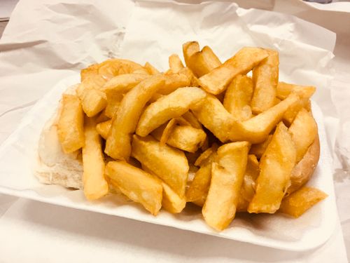 Free A mouthwatering close-up of golden crispy french fries on a white tray. Stock Photo