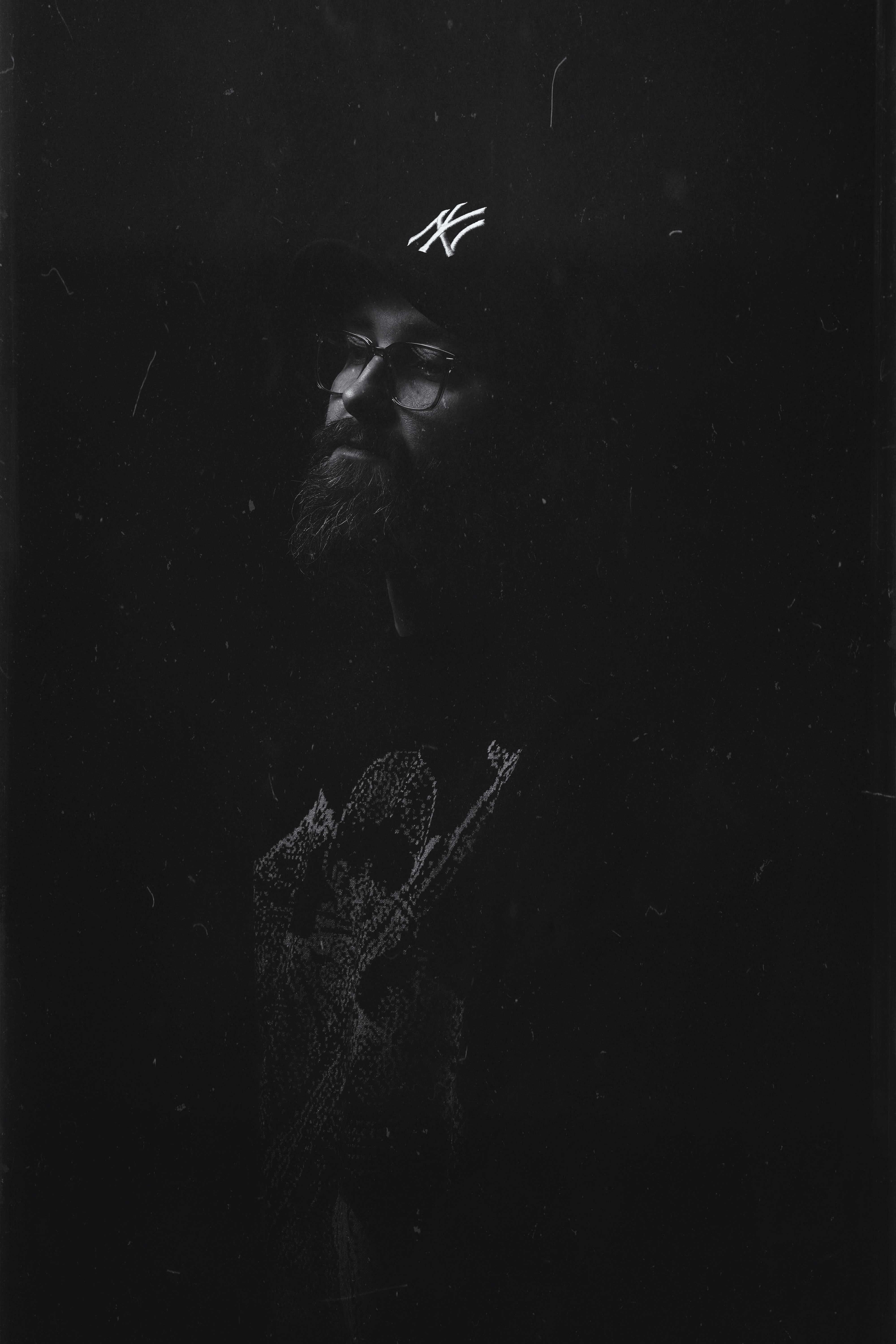 Artistic black and white portrait of man in hat with contemplative mood.