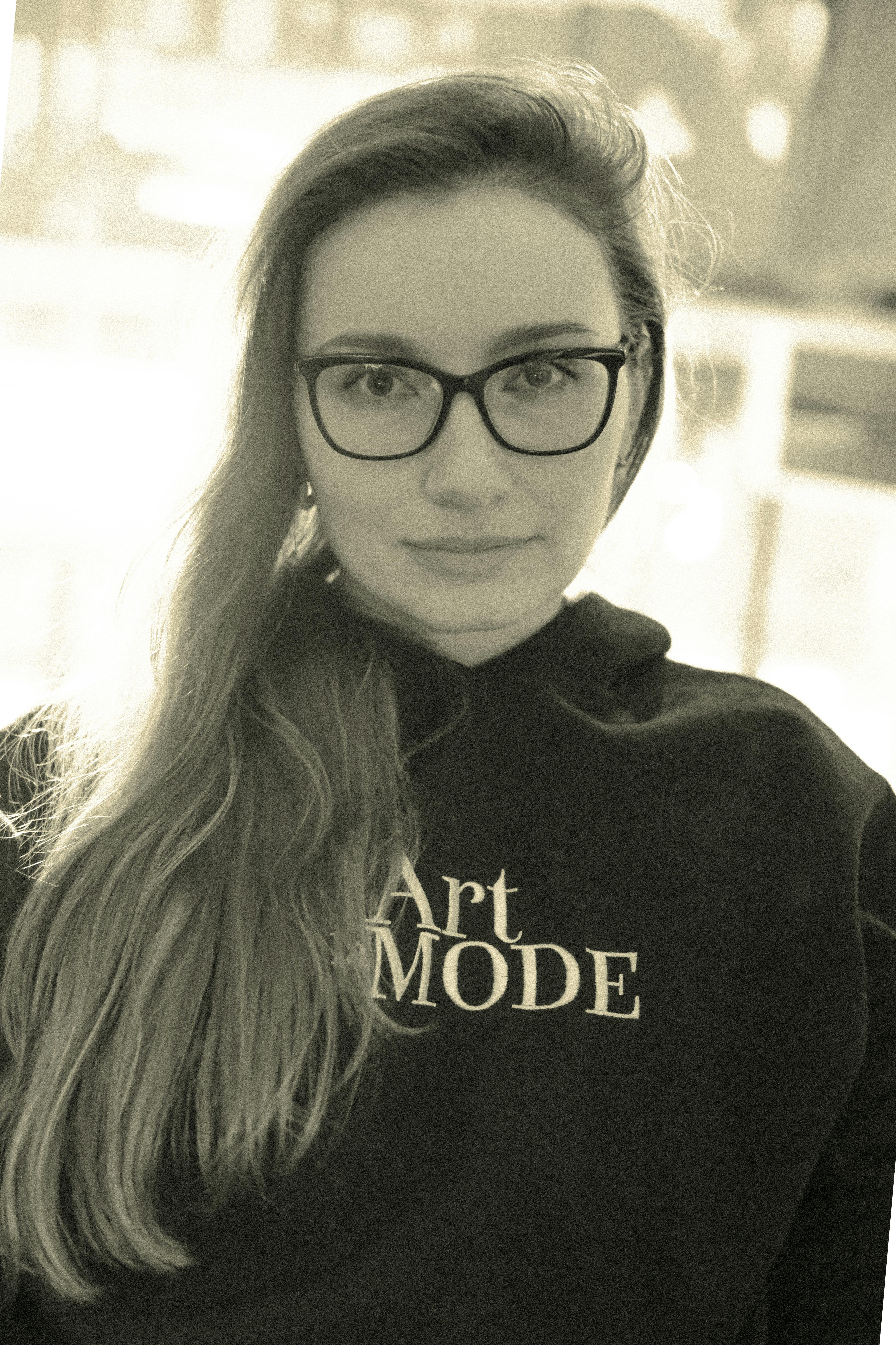 Zadarmo Mladá žena v okuliaroch a mikine s kapucňou Art Mode, portrét v sépiovom tóne. Fotka z fotobanky