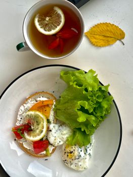 Top view of a nutritious breakfast with poached eggs, toast, and herbal tea.