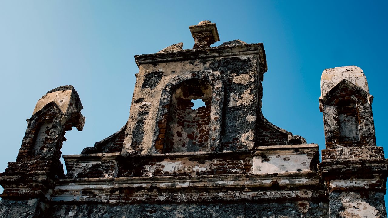 ancient weathered ruins with a clear blue sky backdrop highlighting hi