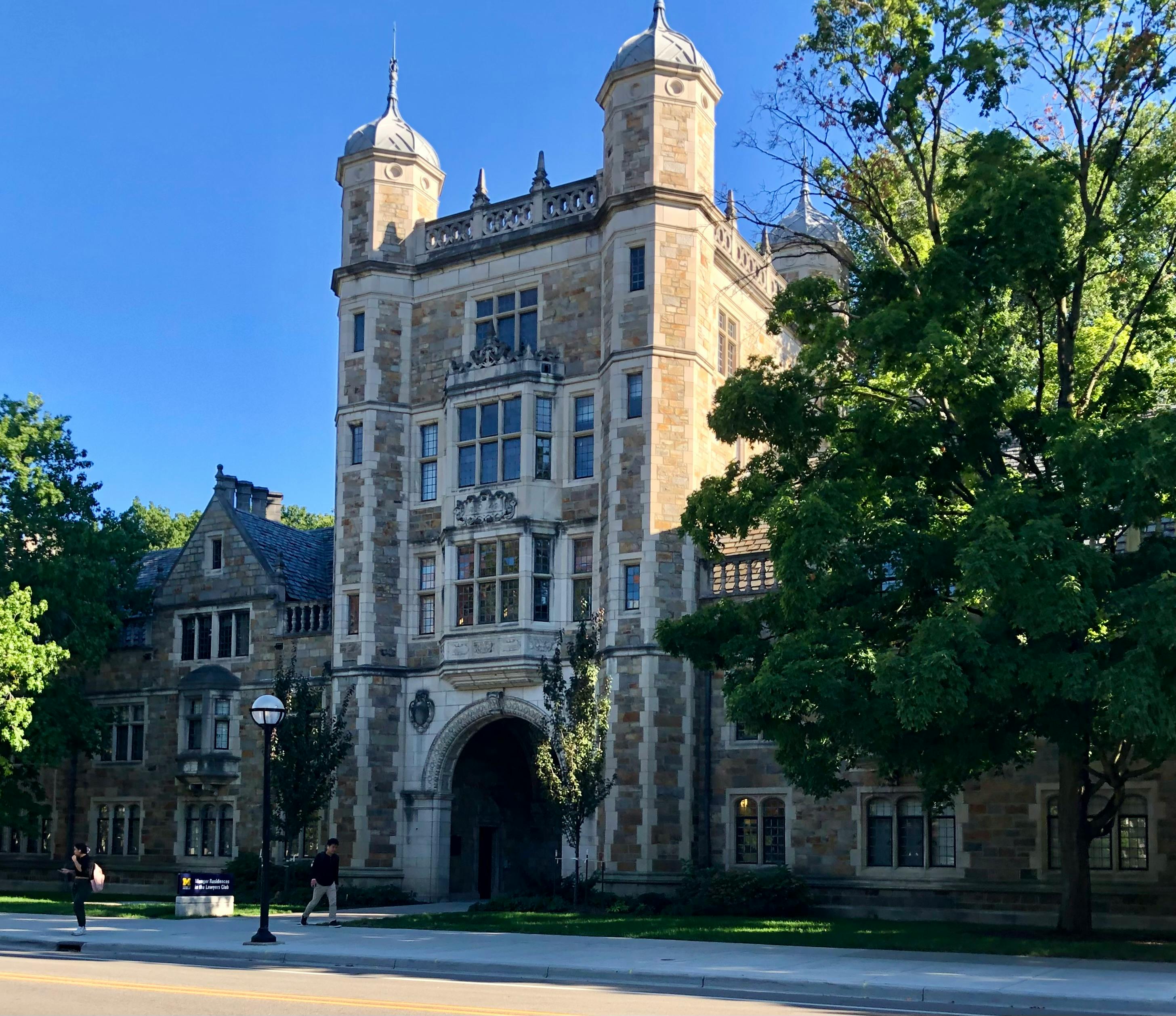 Stunning Gothic Revival architecture of a university building with lush greenery.