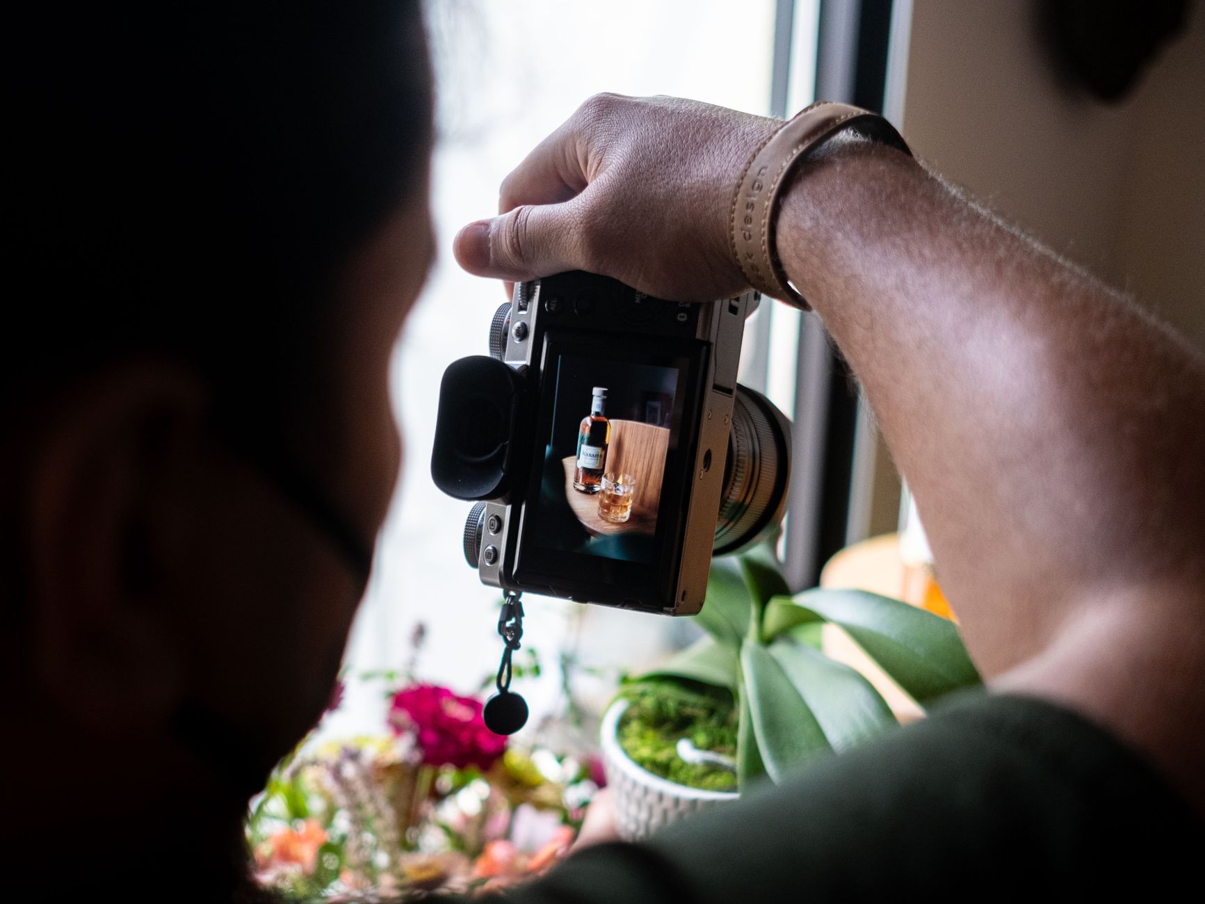 Photographer shoots a product with a camera in a creative indoor setup.