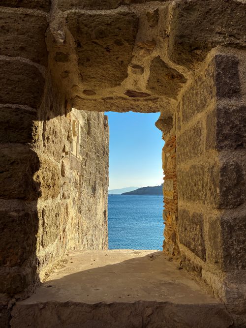 Free Serene stone window framing a peaceful sea view with a distant horizon. Stock Photo