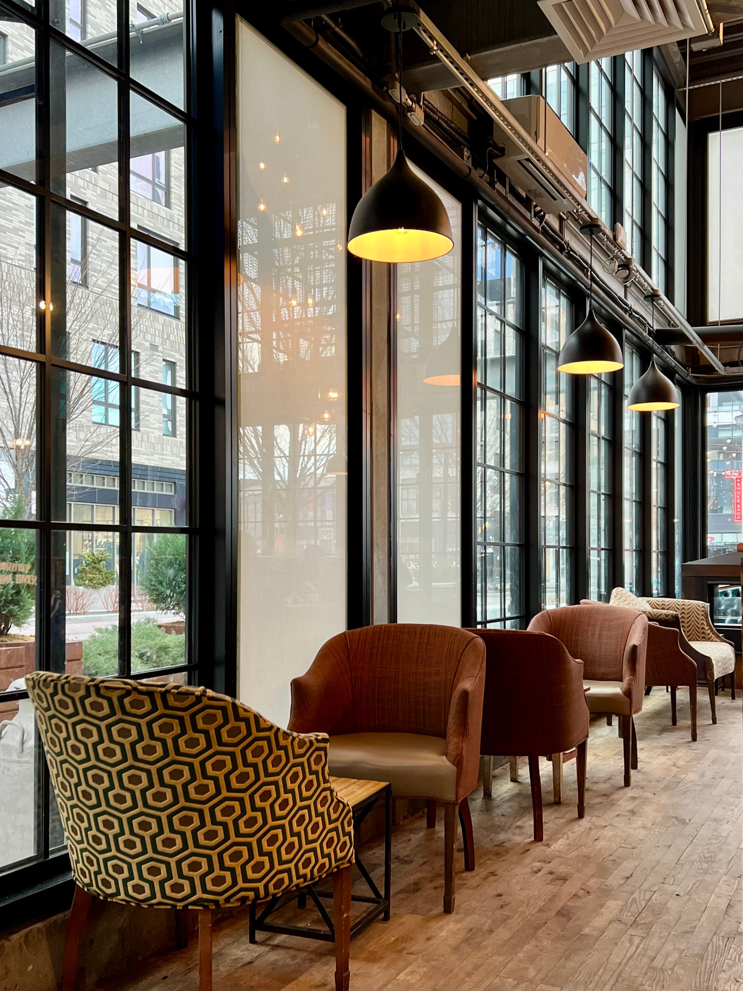 Modern Cozy Indoor Cafe Seating with Large Windows · Free Stock Photo