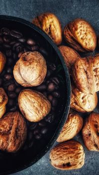 A close-up of walnuts and coffee beans arranged in a rustic bowl on a wooden surface, evoking warmth and simple pleasures.