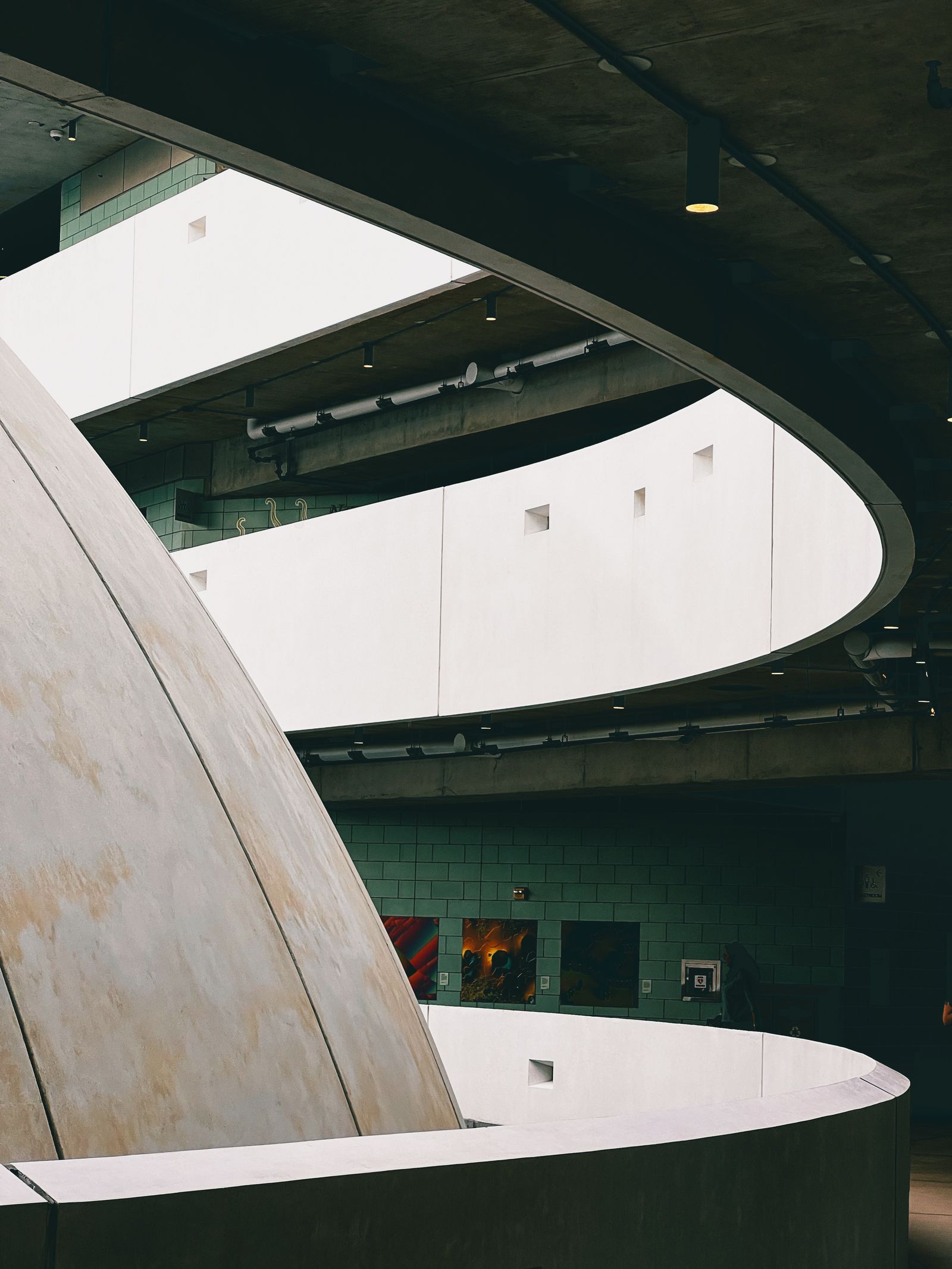 Minimalist curved architectural interior with sculptural concrete forms and light.