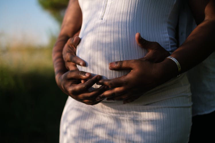 Hands Of A Couple Embracing The Baby Inside Her Growing Belly