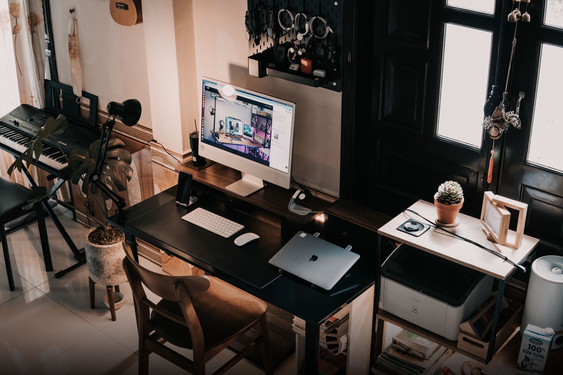 A cozy home office setup featuring a computer desk and musical instruments.