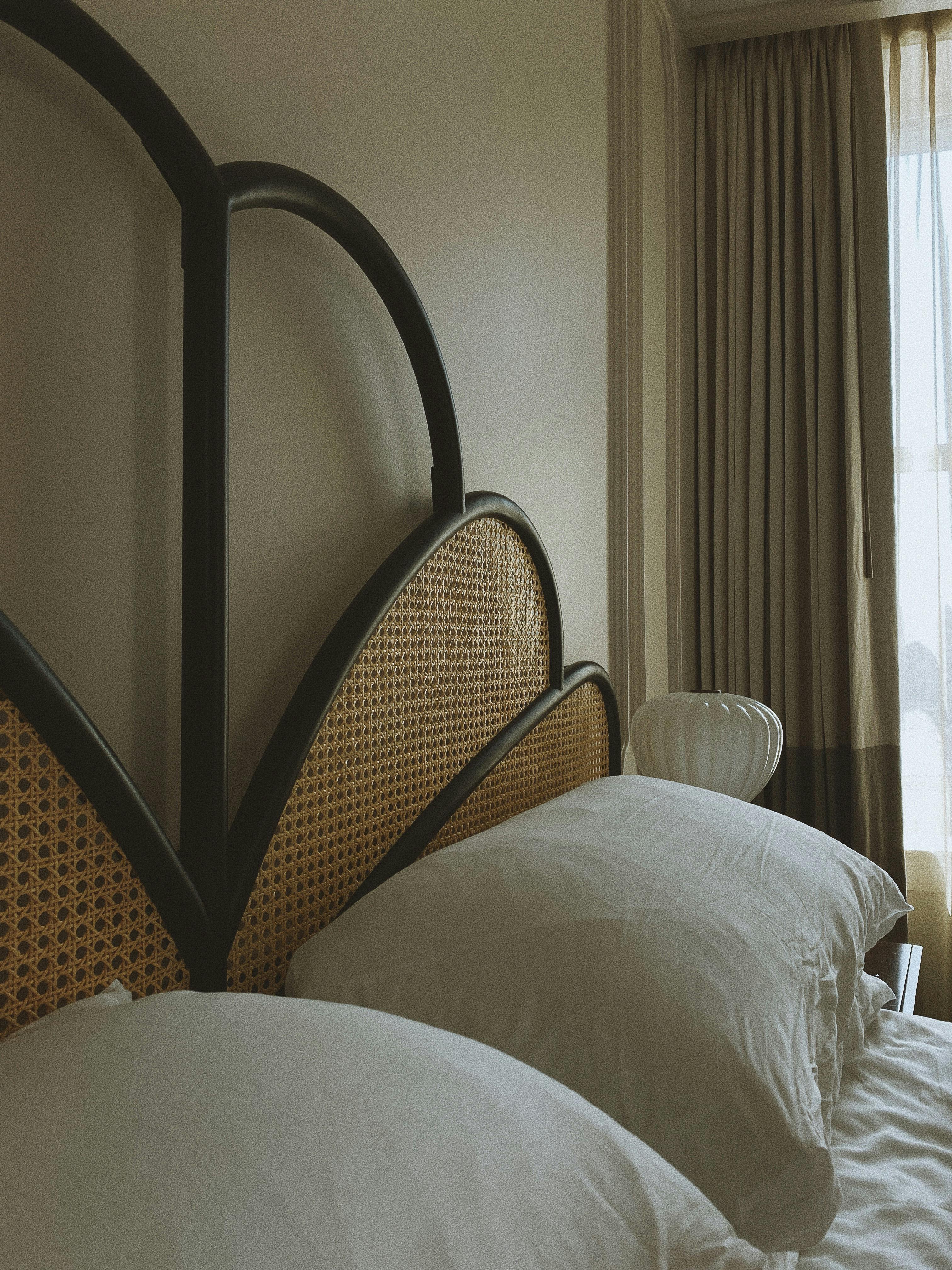 Elegant bedroom with rattan headboard and soft pillows in Los Angeles.