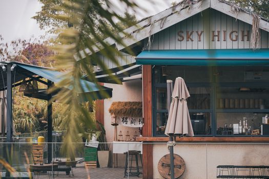 Rustic outdoor cafe setting with cozy decor and inviting atmosphere, featuring wooden furniture and natural elements.